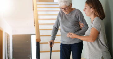 Homecare helping elderly woman going down the stairs